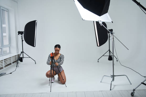 istock Calm woman dancer putting smartphone at the tripod while preparing broadcasting at the studio 1371273748