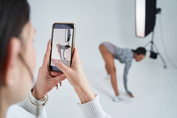 istock Female assistant shooting backstage at the smartphone while multiracial dancer posing at the studio 1371273770
