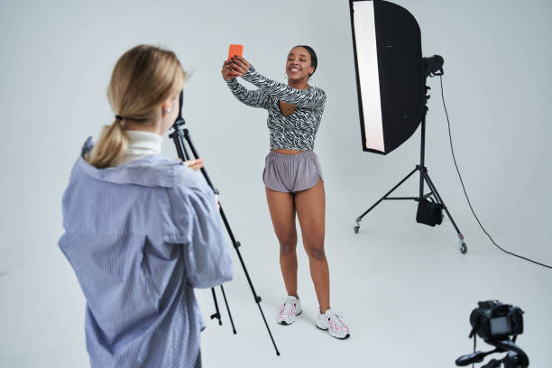 istock Photographer having break during the shooting while her multiracial model making selfie at the smartphone 1371273774
