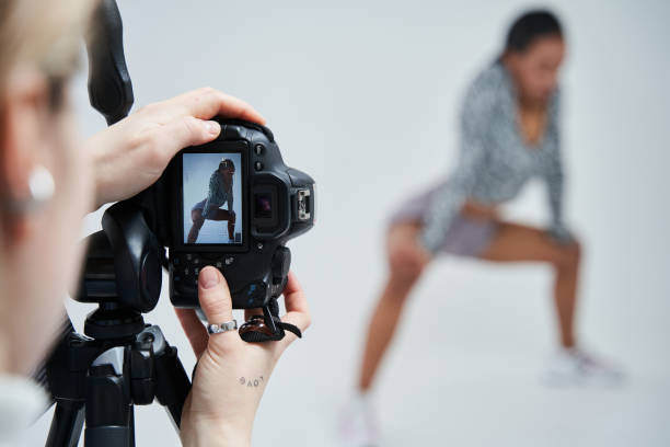 istock Photographer standing at the studio and making photo session for her multiracial model 1371273787