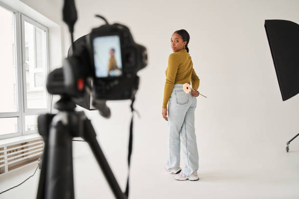 istock Multiracial professional model standing with camomile at the studio and posing to the camera 1371273834
