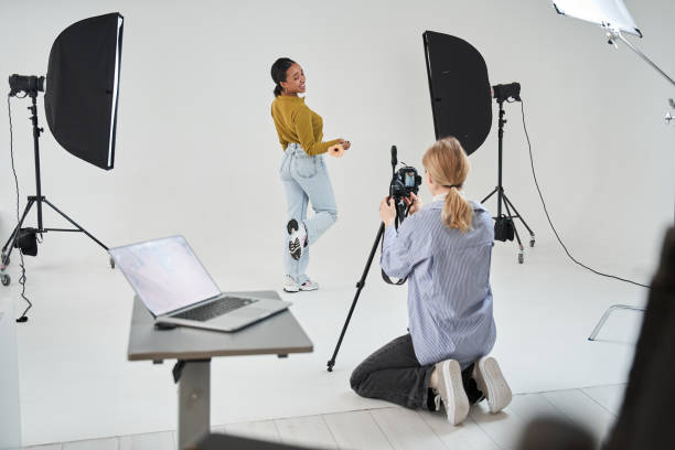 istock Photographer kneeling at the studio while shooting her multiracial model at the professional equipment 1371273841