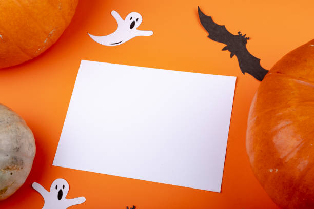 istock Composition of halloween decoration with ghost, bat and sheet with copy space on orange background 1371275204