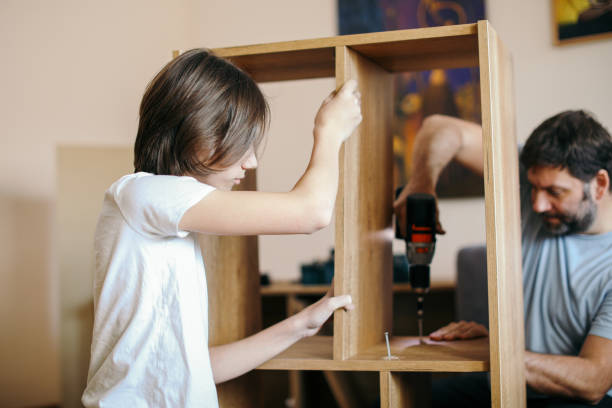 istock Father and son assembling bookshelves at their home 1371278814