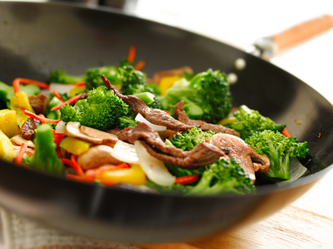 broccoli, beef, onions, peppers, mushroom, and carrots, stir fried in a wok. (note- selective focus)