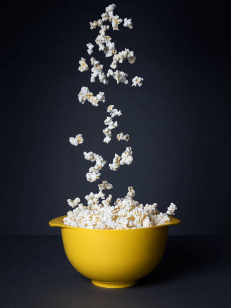 검은 색 배경에 노란색 그릇에 떨어지는 팝콘 - popcorn snack bowl isolated 뉴스 사진 이미지