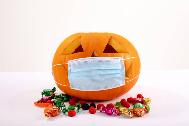 istock Halloween jack o lantern with face mask on white background 1371281514