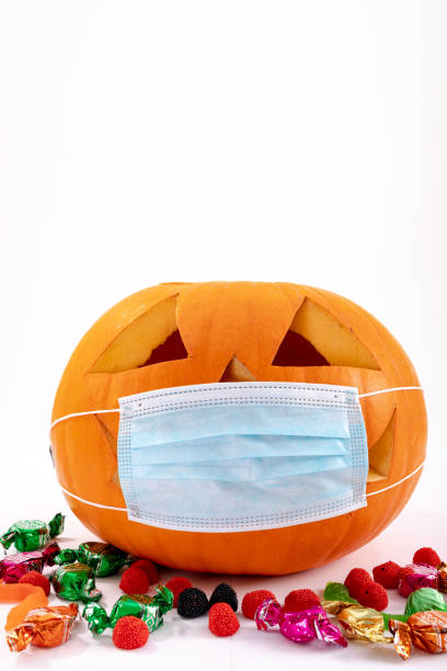 istock Halloween jack o lantern with face mask on white background with sweets 1371282541