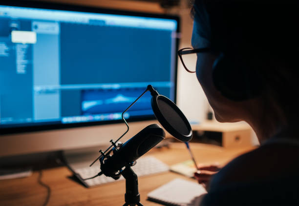 Microphone with pop filter closeup photo with a young woman in headphones recording voice using a desktop computer with music creation studio app. Modern home sound studio audio recording technology. micrófono con filtro pop foto de primer plano con una mujer joven con auriculares grabando voz usando una computadora de escritorio con la aplicación de estudio de creación de música. moderna tecnología de grabación de audio de estudio de sonido dom�