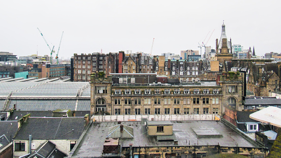 Glasgow cityscape, United Kingdom. Roofs of multiple old residential and modern buildings, cloudy weather