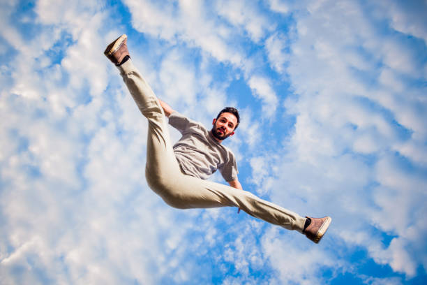 istock Carefree man below white clouds doing parkour training 1371286126
