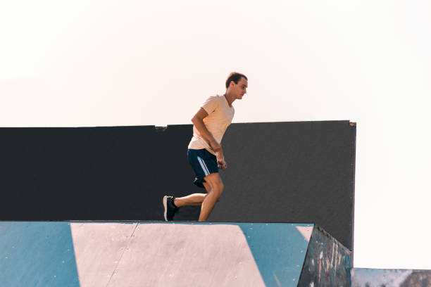 istock Sporty man training jumping over wall in skatepark 1371286833