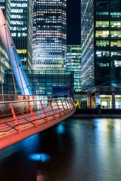 Footbridge to Canary Wharf in London Illuminated Footbridge in Financial District, Docklands, Canary Wharf, London london docklands stock pictures, royalty-free photos & images