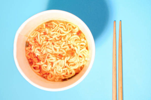 istock A bowl with ready instant noodles and chopsticks on blue background, top view 1371294109
