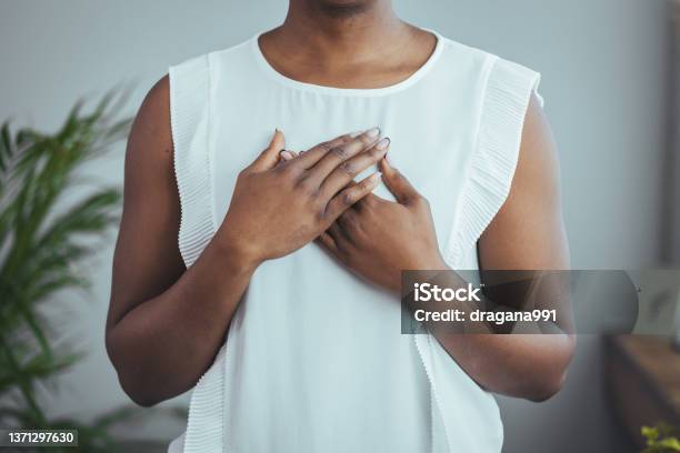 Cropped Close Up Smiling Grateful Woman Holding Folded Hands On Chest Stock Photo - Download Image Now
