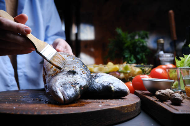 istock Preparing fresh gilthead bream for roasting with vegetables 1371298088