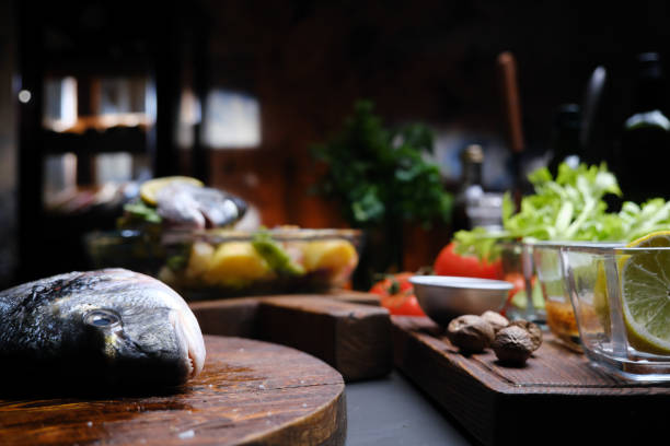 Preparing fresh gilthead bream for roasting with vegetables