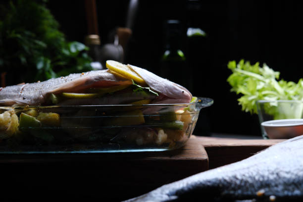Preparing fresh gilthead bream for roasting with vegetables