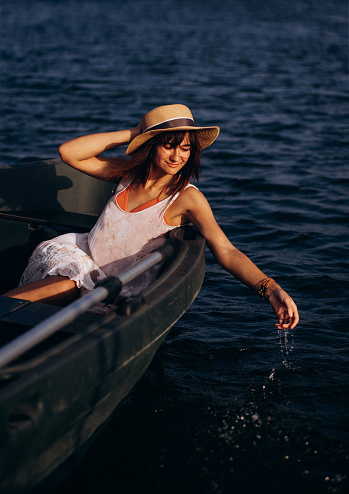 Perfect woman. Beautiful young woman in dress sitting in the rowboat . Adventure and vacation travel concept.