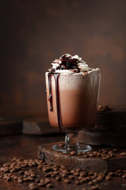 Coffee and chocolate cocktail with whipped cream. Coffee and chocolate cocktail with whipped cream on a brown background. macchiato stock pictures, royalty-free photos & images