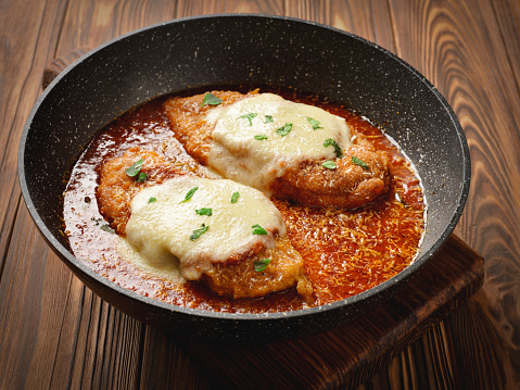 Frying pan with freshly cooked chicken parmesan