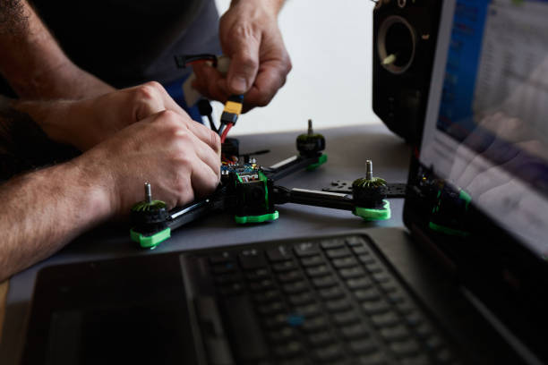 istock Close up of man's hands assembling a drone from parts, using tools, Preparing high-speed racing quadcopter for flight. Repair drone before training process. 1371306232