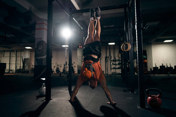 istock Unrecognizable strong man doing the handstand push-ups at the gym 1371307494