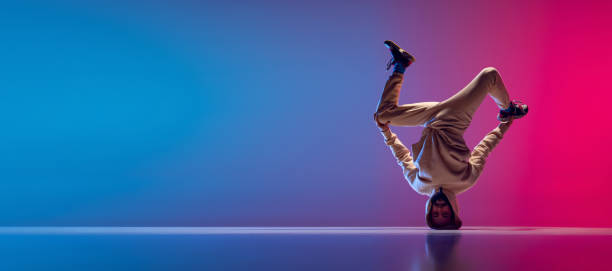 istock Flyer with young flexible sportive man dancing breakdance in white outfit on gradient pink blue background. Concept of action, art, beauty, sport, youth 1371308002