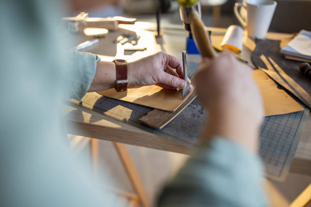 istock Female leather craftsman making custom made leather wallet in her workshop 1371309705