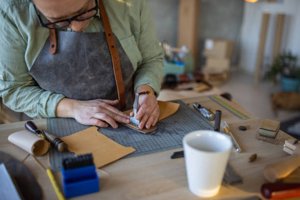 istock Skilled leather craftsman working on new wallet in her workshop 1371309707