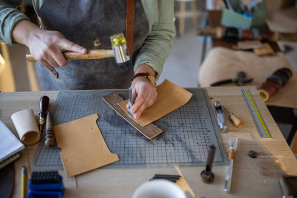 istock Skilled leather craftsman working on new wallet in her workshop 1371310411
