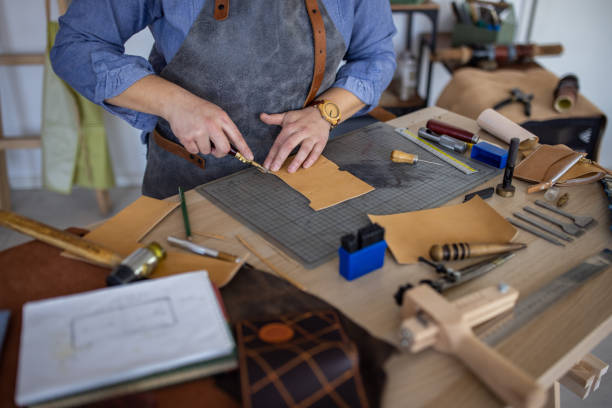 istock Female leather craftsman making custom made leather wallet in her workshop 1371310839