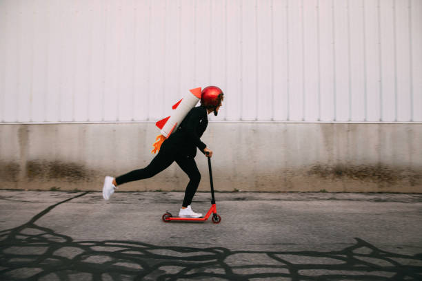 A businesswoman dressed in business attire wearing a homemade rocket pack gets ready to launch her new business.