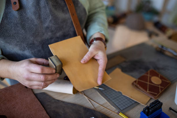 istock Artisan making handmade leather wallet in her workshop 1371311973