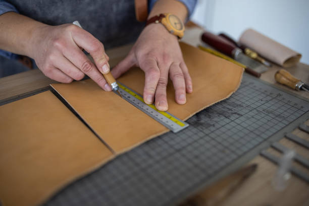 istock Skilled leather craftsman cutting material for wallet in her workshop 1371311993