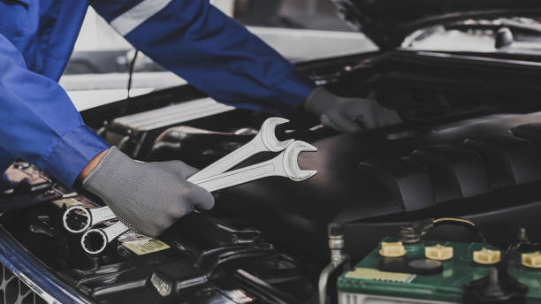 Mechanic works on the engine of the car in the garage.Concept of car inspection service and car repair service. stock photo