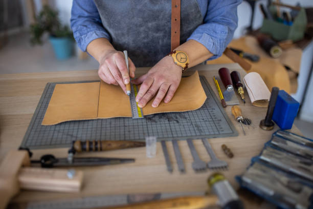 istock Leather craftsman measuring material for new wallet in her workshop 1371313292