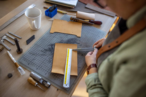 istock Skilled leather craftsman working on new wallet in her workshop 1371313548