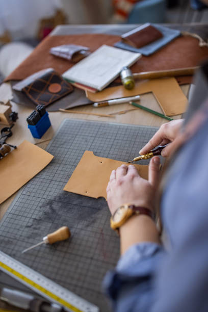 istock Artisan making handmade leather wallet in her workshop 1371313551