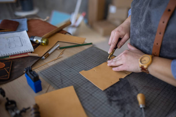 istock Skilled leather craftsman cutting material for wallet in her workshop 1371313970