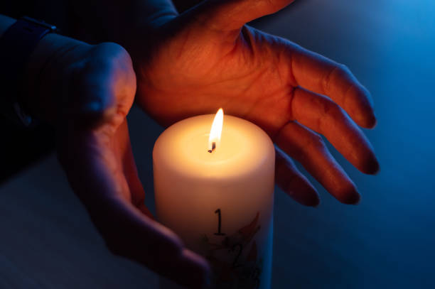 istock Burning candle with number 1 and hands warming near flame 1371316749