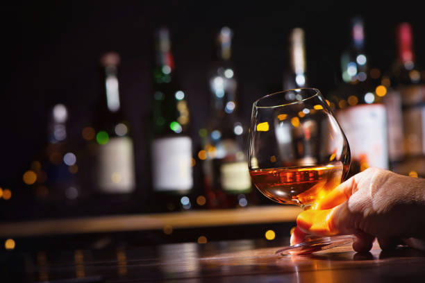 위스키 또는 브랜디 한 잔을 곁들인 남성 손 - brandy 뉴스 사진 이미지