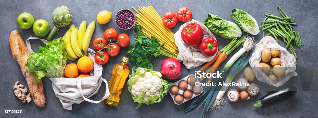 Groceries shopping. Flat lay of fruits, vegetables, greens, bread and oil in eco friendly bags, top view. Groceries shopping. Flat lay of fruits, vegetables, greens, bread and oil in eco friendly bags, top view. Healthy eating and sustainability concept Healthy Eating Stock Photo