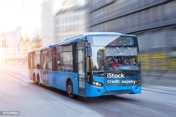 Blue Bus Moving On The Road In City In Early Morning Stock Photo - Download Image Now