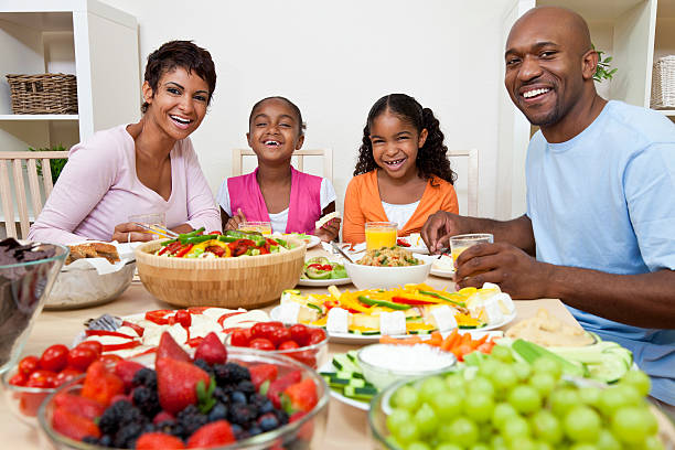 famille afro-américaine parents et enfants manger à table de salle à manger - beautiful smiling vegetable calcium photos et images de collection