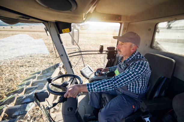istock Senior farmer driving combine. 1371319816