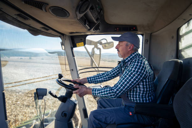 istock Senior farmer driving combine. 1371319823