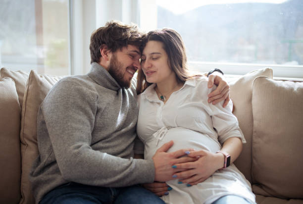 istock Happy future parents on the couch at home. 1371319831