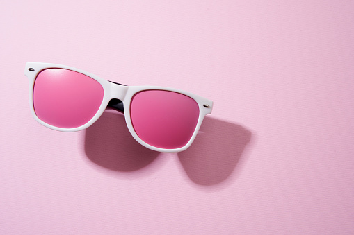pink color sun glasses on the pink background with shadow