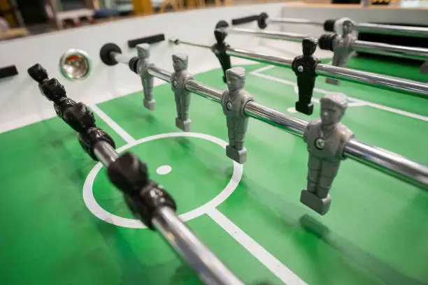 Close up photo of table football players, black and grey.
